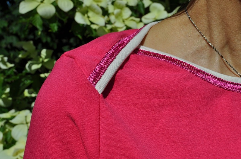 Amerikanischer Ausschnitt mit Binding und dekorativer Covernaht an einem pinken Shirt
