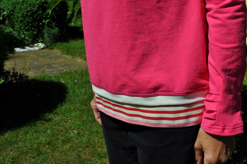 Saumdetail eines fertigen Shirts mit amerikanischem Ausschnitt und gestreiftem Bündchen