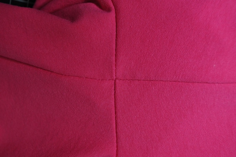 Saubere Nahtkreuzung an einem pinken Shirt mit amerikanischem Ausschnitt