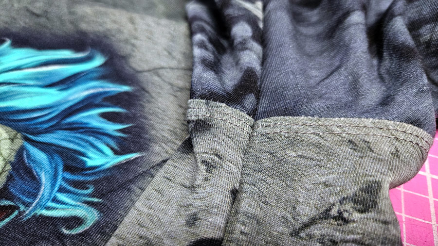 Perfekt aufeinandertreffende Covernähte an der Seitennaht eines Shirts mit Negativapplikation.