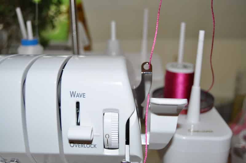 Garnführung mit pinkem Decora-Garn an einer Covermaschine
