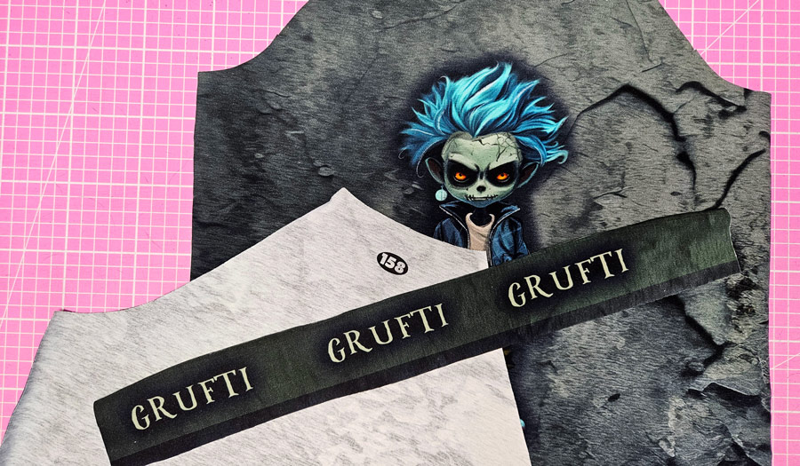 Materialien für ein Shirt mit Negativapplikation: Vorderteil, Rückteil und bedruckter Stoffstreifen.