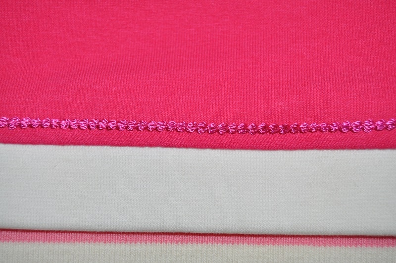 Detail einer dekorativen Covernaht am Saum eines Shirts mit amerikanischem Ausschnitt