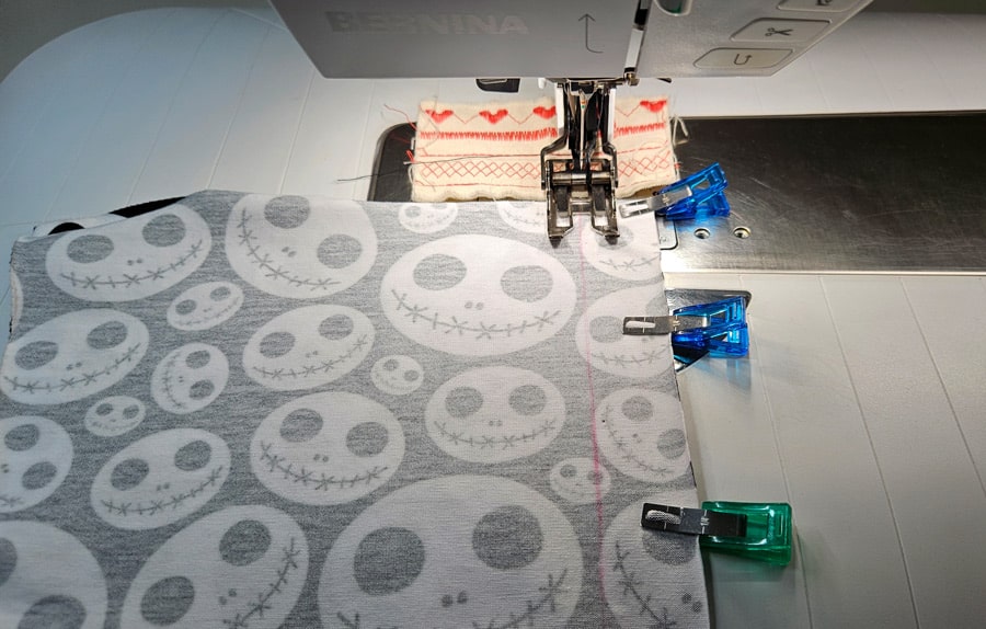 Das Rückenteil eines Shirts wird an der Nähmaschine zusammengenäht.