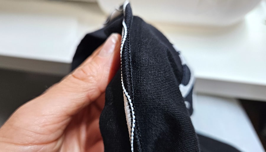 Detailansicht einer noch hochstehenden Wave-Flachnaht am Ärmelsaum eines Shirts.
