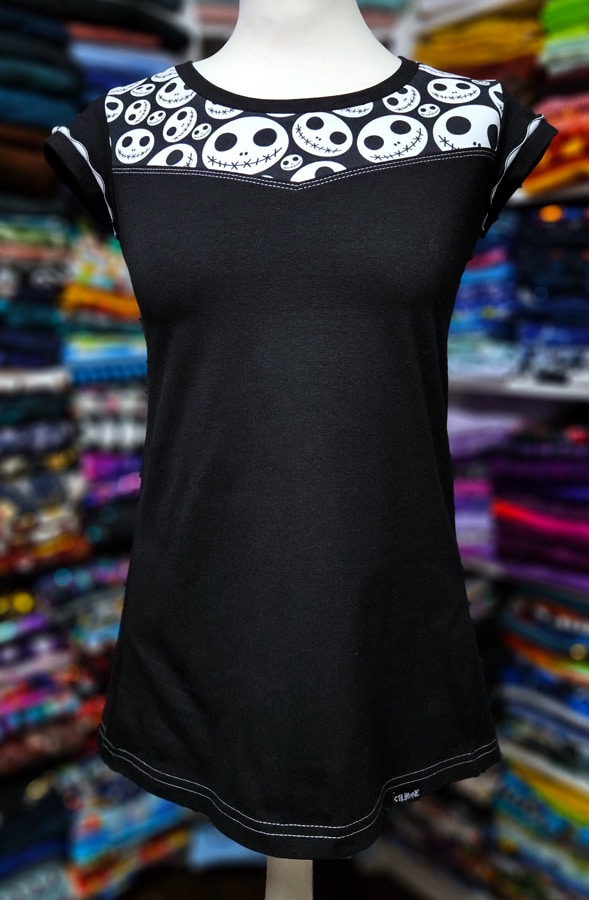 Fertiges schwarzes Shirt mit eckiger Teilung, Musterstoff und Wave-Flachnaht an den Ärmeln.