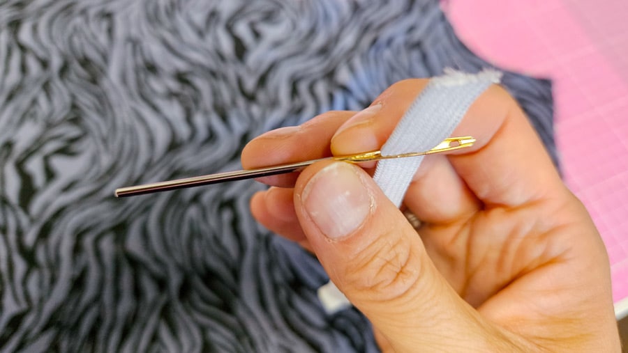 Elastisches Gummiband wird mithilfe einer Einziehnadel für den Tunnel der Bluse vorbereitet.