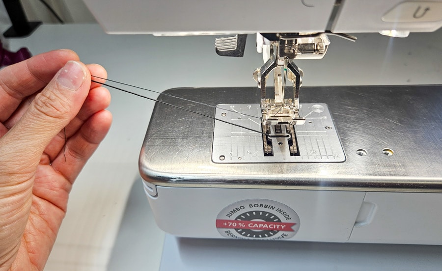 Gummifaden der Unterfadenspule wird vor dem Smoken mit der Nähmaschine nach oben geholt.