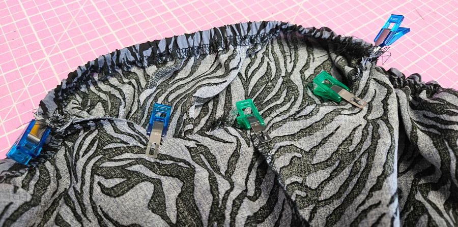 Ärmel der gesmokten Viskosebluse wird mit Stoffklammern an Vorder- und Rückteil gesteckt.