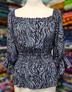 Fertige gesmokte Bluse aus gemusterter Viskose-Webware mit geraffter Taille und langen Ärmeln.