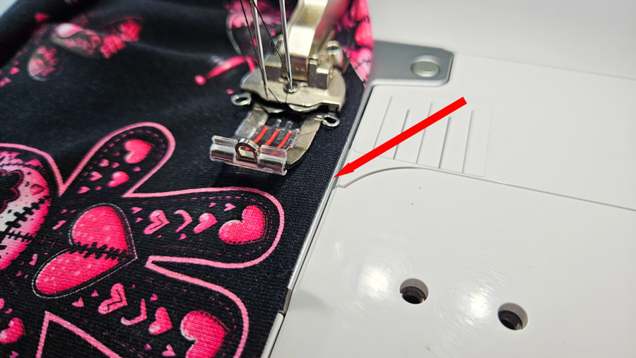 Vorgebügelter Saum des Jersey-Tops wird an der Coverstitch ausgerichtet